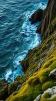 A rocky cliff with green moss on it photo