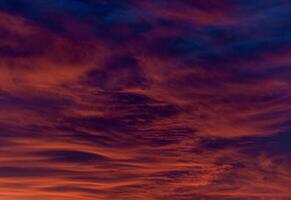 Dramatic sunset with fiery orange and red hues swirling through textured clouds. Abstract and intense, evoking a sense of power and awe photo