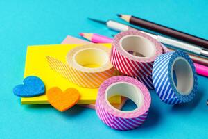 Colorful stationery items arranged on a bright blue background for crafting and organization tasks photo