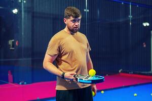 Man practices paddle tennis indoors at a sports facility during a training session photo