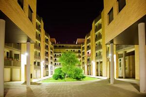 architecture Night Scene.Inside of a block of flats with garden and tree photo