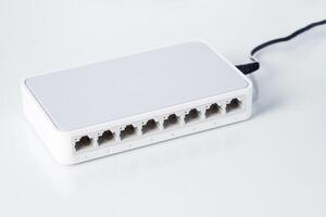 Ethernet network switch with eight ports on a clean background, used for internet connectivity and data distribution. photo
