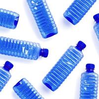 Pattern with blue plastic bottles isolated on white, top view empty plastic bottle for water half litre, minimal style design. Pollution, plastic garbage, environmental protection concept photo