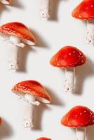 Red mushrooms with white spots as minimal pattern on light background, natural textures ad organic beauty, vivid fly agaric with bright red caps and white stems, Creative flat lay still life photo