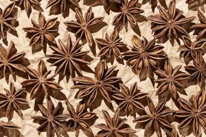 Anise stars as pattern at sunlight, top view close up spices dried trend color 2025 mocha mousse on paper, minimal aesthetic food, textured background, natural season traditional condiments, flat lay photo