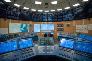 Control room monitoring showing multiple screens displaying data and information for managing operations photo