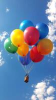 A box with a bunch of colorful balloons floating in the sky photo