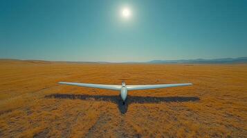 A glider in a field with the sun in the background photo