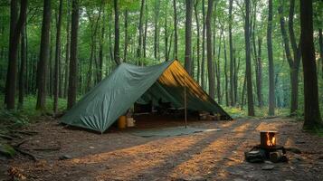 A tent in the woods with a fire photo