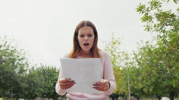 Girl Amazed And Shocked After Reading A News On Paper Outdoor In Public Park video