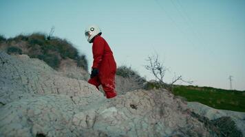 astronaute avec Orange costume et casque des promenades sur le rochers de une hostile planète video