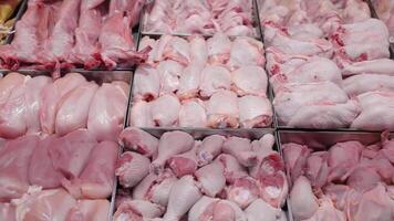 Chicken products on a shop window. Chicken fillet and chicken drumsticks are placed in containers in the window of a supermarket. video