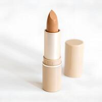 Lipstick of beige shade on the white background. Cosmetics product photo