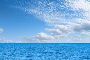 Blue sea and white clouds on sky. Water cloud horizon background. Feeling calm, cool, relaxing. The idea for cold background and copy space on the top. the ocean deep indigo photo