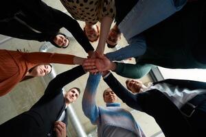 A group of business professionals, captured from a low angle, holding hands to symbolize unity and teamwork. photo