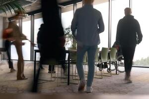 A diverse business team, working urgently around a conference table, collaborates on a meeting while their director, seated in a wheelchair, waits for their input photo