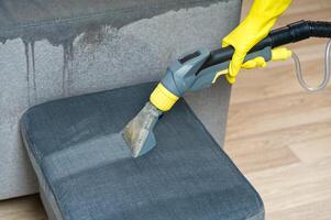 Sofa chemical cleaning with professionally extraction method. Wet textile sofa cleaning. home cleaning service. cleaning sofa with washing suction cleaner closeup. photo