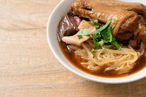 Braised duck noodles with brown soup in bowl photo