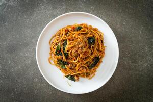 Stir Fried Spaghetti with Clam and Chilli Paste on white plate photo