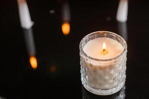 Cozy Lit Candle on Reflective Surface photo