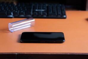 Smart phone on Leather Desk with Keyboard photo