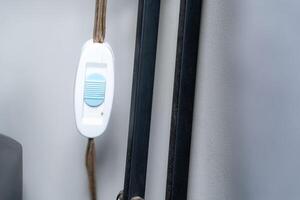 A white and blue cord attached to a wall photo