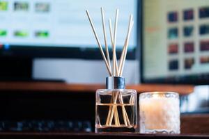 A desk with a computer monitor and a candle photo