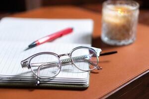 A pair of glasses and a pen on a notepad photo