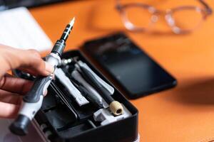 A person holding a pen and a pair of scissors photo