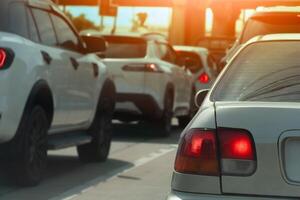 Rear side of car with turn on brake light. Traffic of car line up in a queue during time of business or travel trip. Background of Concrete bridge pillars with orange sun. photo