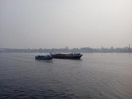 two boats floating on the water in front of a city photo