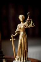 A refined law office with a vintage clock on a wooden shelf and a symbolic statue of Themis. photo