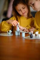The kids are engaged in a friendly match, playing a childrens game on the table. photo
