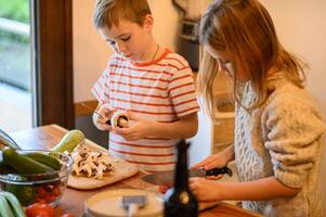 The siblings team up in the kitchen, preparing fresh vegetables for a meal. photo