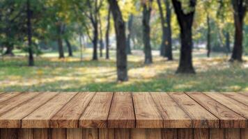 Empty wood table with green tree at park bokeh blur background copy space for display of product video