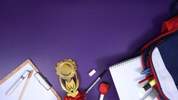 School Stationery with Backpack and Wooden Board Isolated on Purple Background with Blank Area for Copy Space. Back to School Concept photo