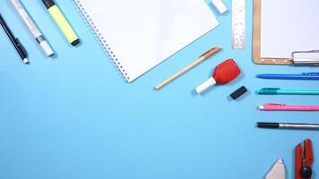 School Stationery, Notebook, and Wooden Clip Board on Blue Background photo