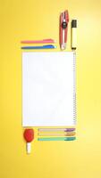 School Stationery and Notebook with Copy Space Area on Yellow Background photo