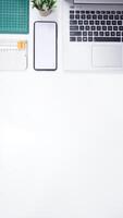 Modern Workspace with Laptop, Mobile Phone, and Work Tools on White Background photo