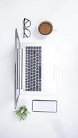 Top View of Laptop with Mobile Phone and Coffee Cup with Copy Space on White Background photo