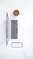 Top View of Laptop with Mobile Phone and Coffee Cup on White Background photo