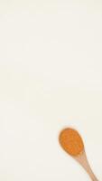Chili Powder on Wooden Spoon on Light Background photo