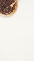 Dried Cloves on Wooden Plate and Spoon on Light Background with Copy Space photo