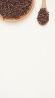 Dried Cloves Spice on Wooden Plate and Spoon on Light Background photo