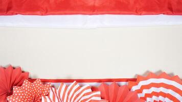 Independence Day of Indonesia Concept with Red and White Flag, Ribbons, and Paper Decorations on Light Background photo