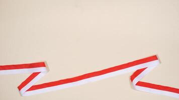 Red and White Ribbons as Symbol of Indonesia Flag on Light Background photo