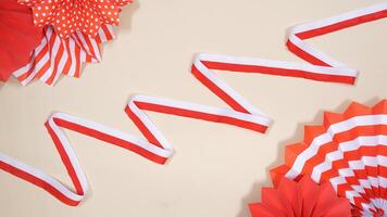 Red and White Ribbons as Symbol of Indonesia National Flag and Paper Decorations on Light Background photo