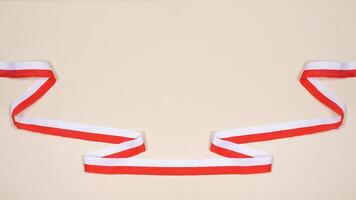 Red and White Ribbons as Symbol of Indonesia National Flag with Copy Space Area on Light Background photo