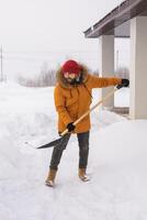 Man is clearing the snow near house and on staircases hovelling at the winter season. Winter storm and season specific photo