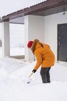 Man cleaning snow from sidewalk and using snow shovel. Winter season photo